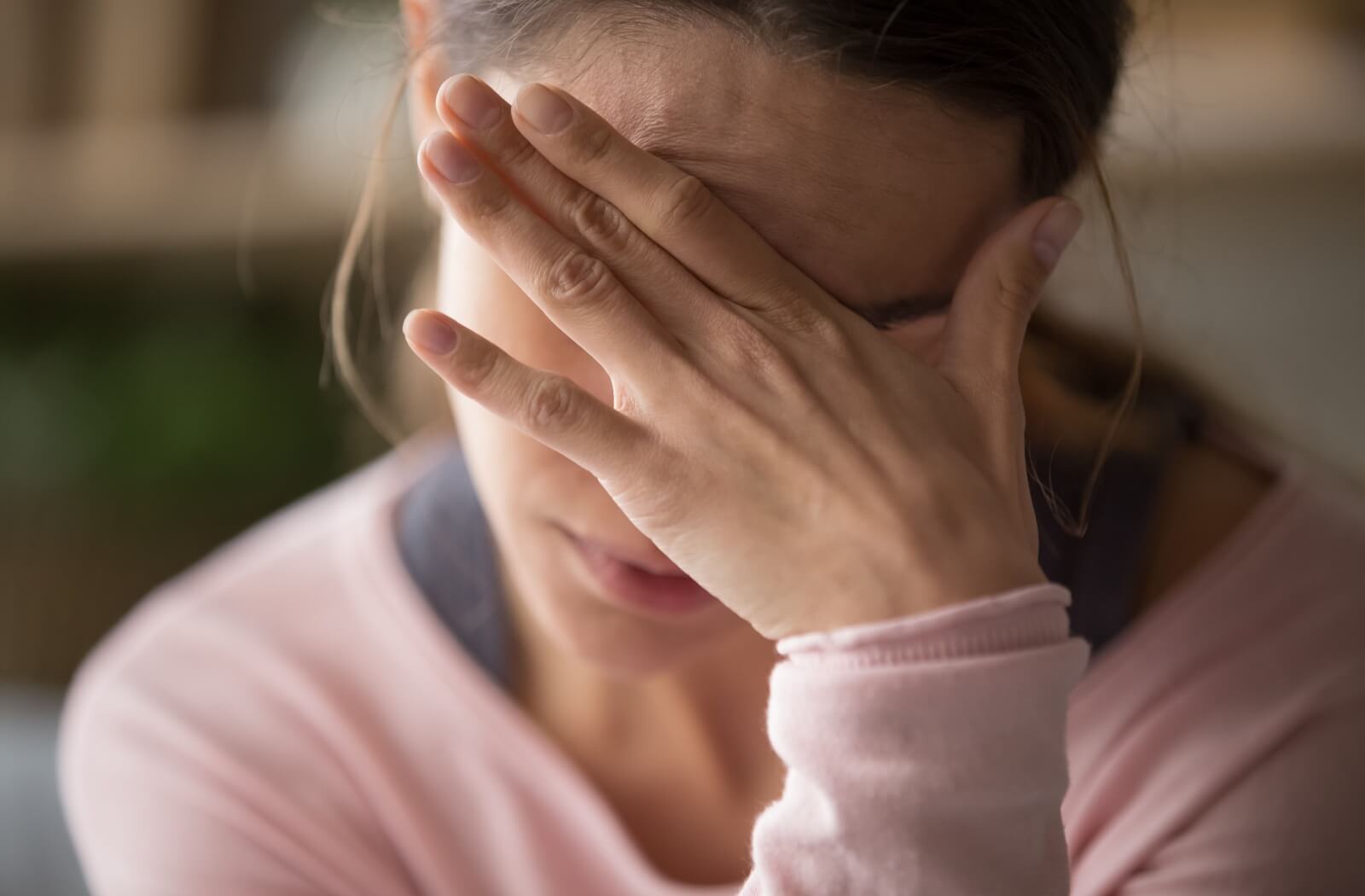 A stressed person covers their eyes as they try to cope with burnout.